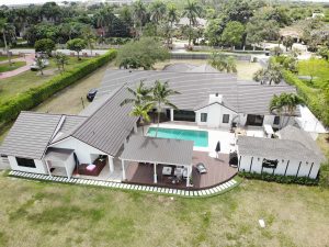 Metal roofing on large Florida home with swimming pool and landscaping.