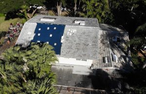 Aerial view of shingle roof being repaired