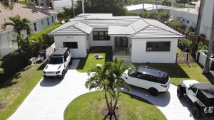 Modern luxury home with white exterior and cars parked out front
