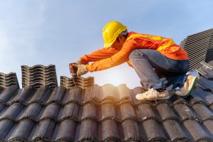 Roofer working on a repair to a concrete tile roof